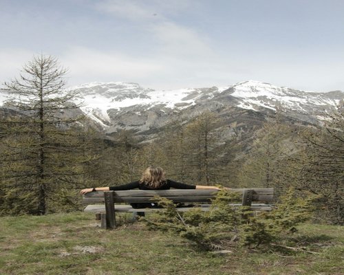 man sitting outdoors looking at mountains relaxed