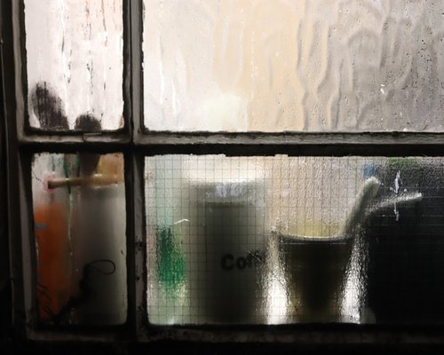 person holding mug resting beside window cozy